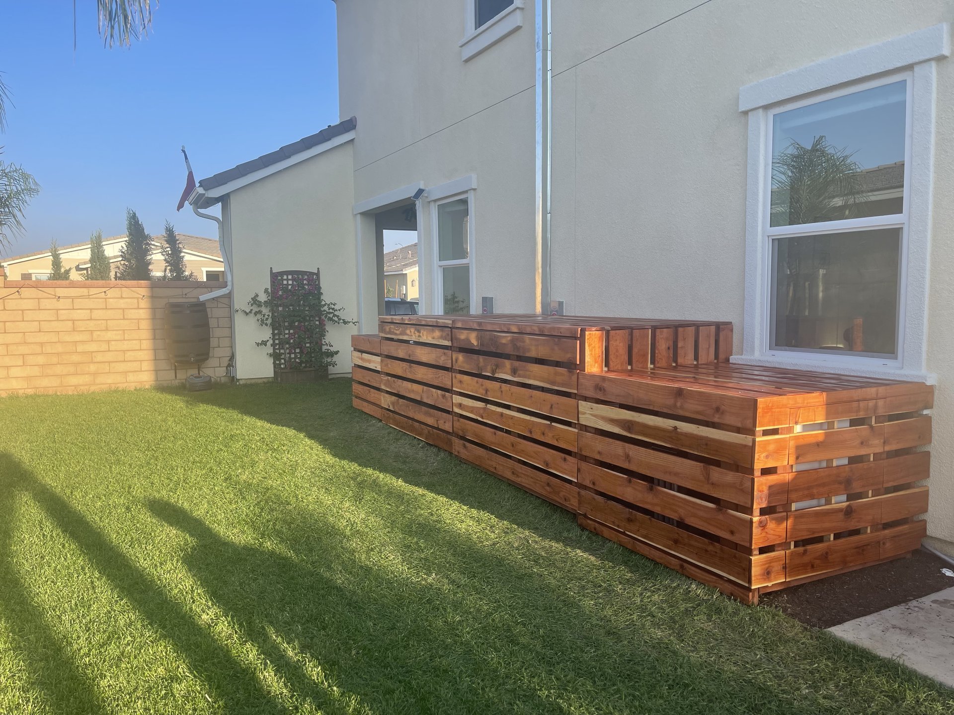 Finished cedar slat enclosure hiding pool equipment and AC units — Menifee, CA