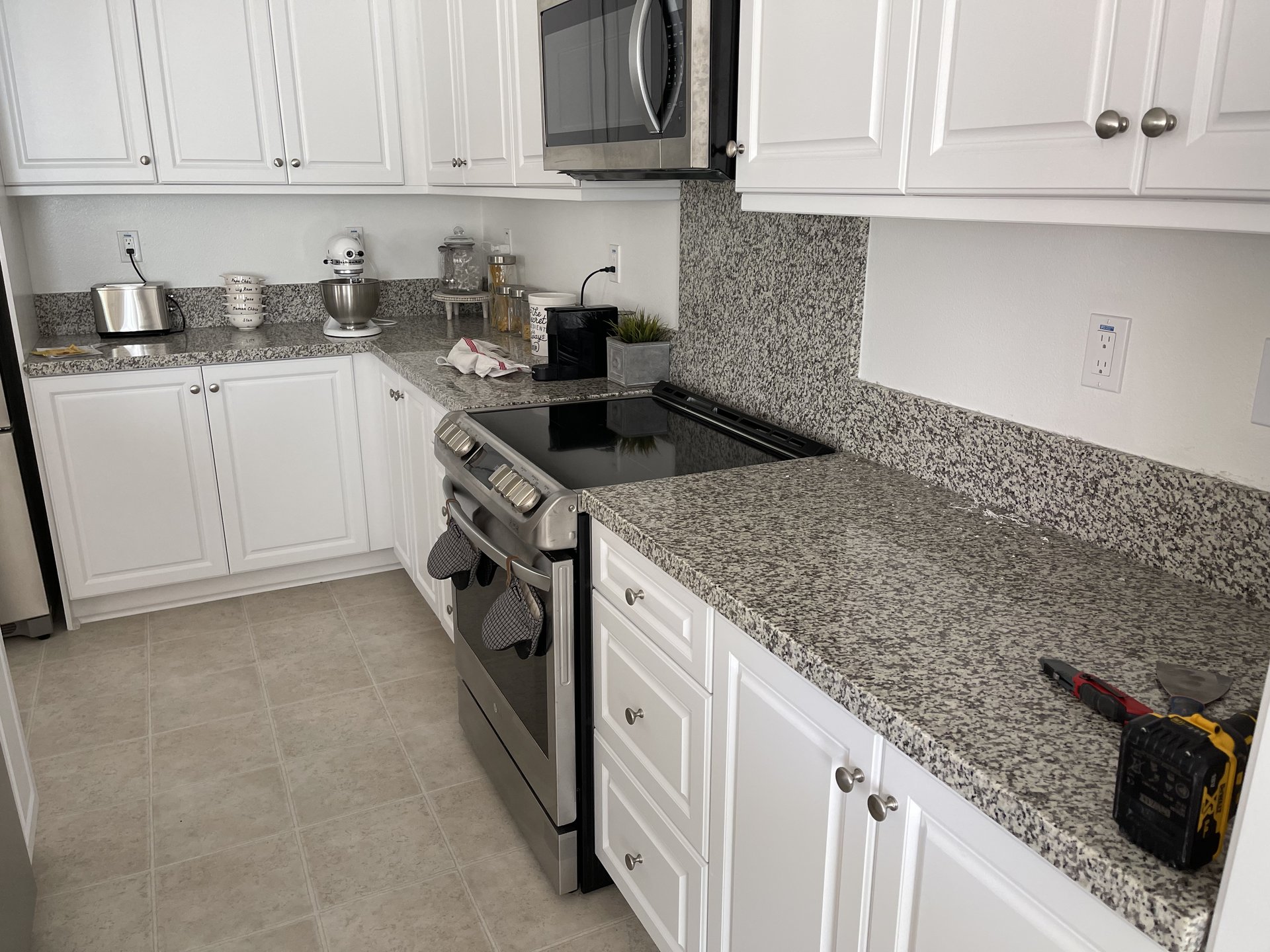 Original kitchen with granite counters and plain backsplash